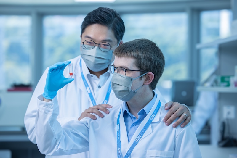 PHASE CEO and employee in lab with testing tube that has liquid inside